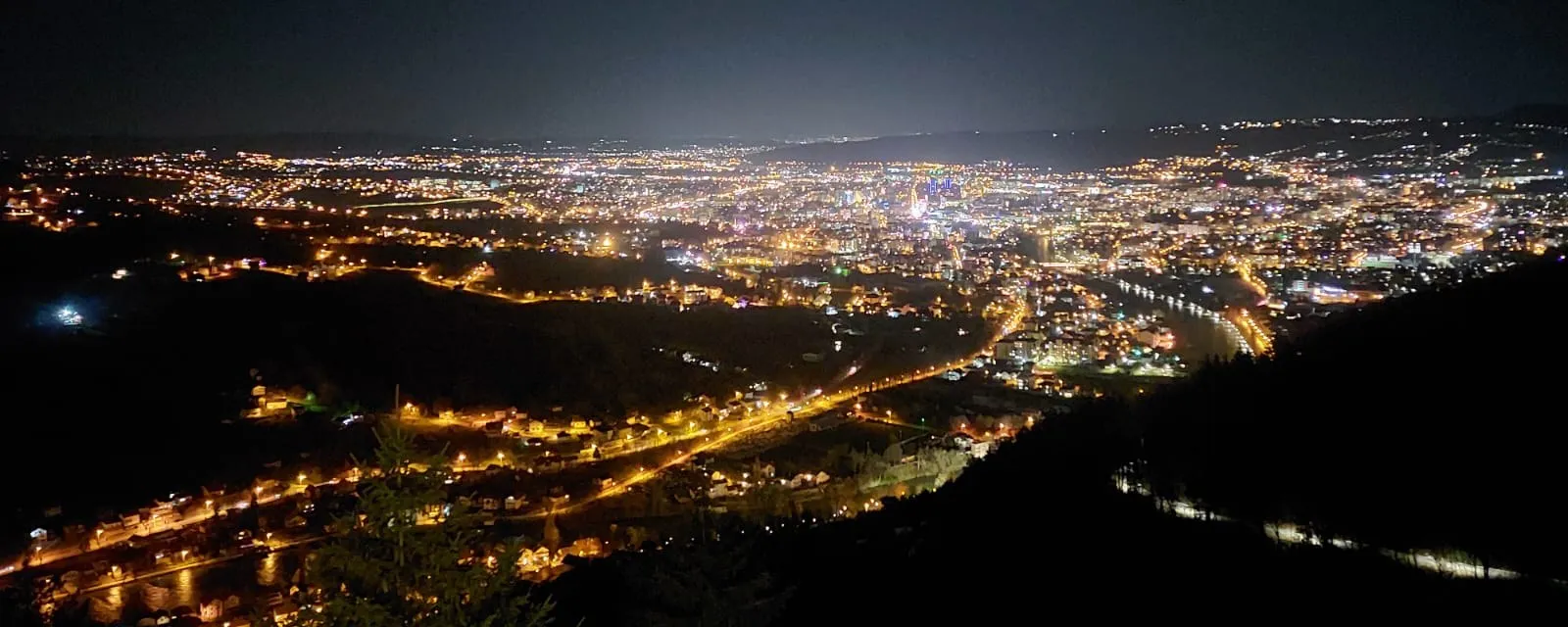 Nächtlicher Blick vom Aussichtspunkt Banj Brdo (Šehitluci) über Banja Luka, im Tal die beleuchtete Stadt und der Fluss.